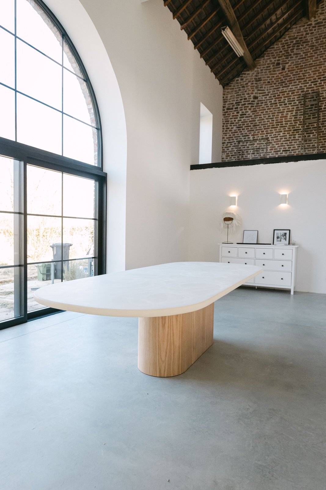 Table à manger en Mortex® sur mesure devant une grande baie vitrée, piètement chêne massif