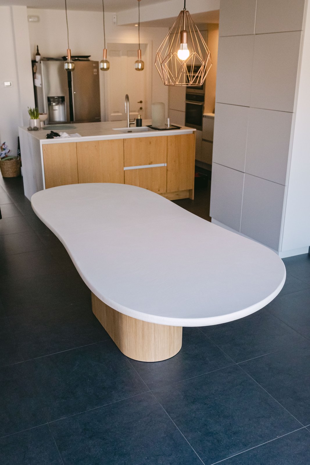 Table en Mortex® intégrée à une cuisine ouverte, béton minéral en usage domestique
