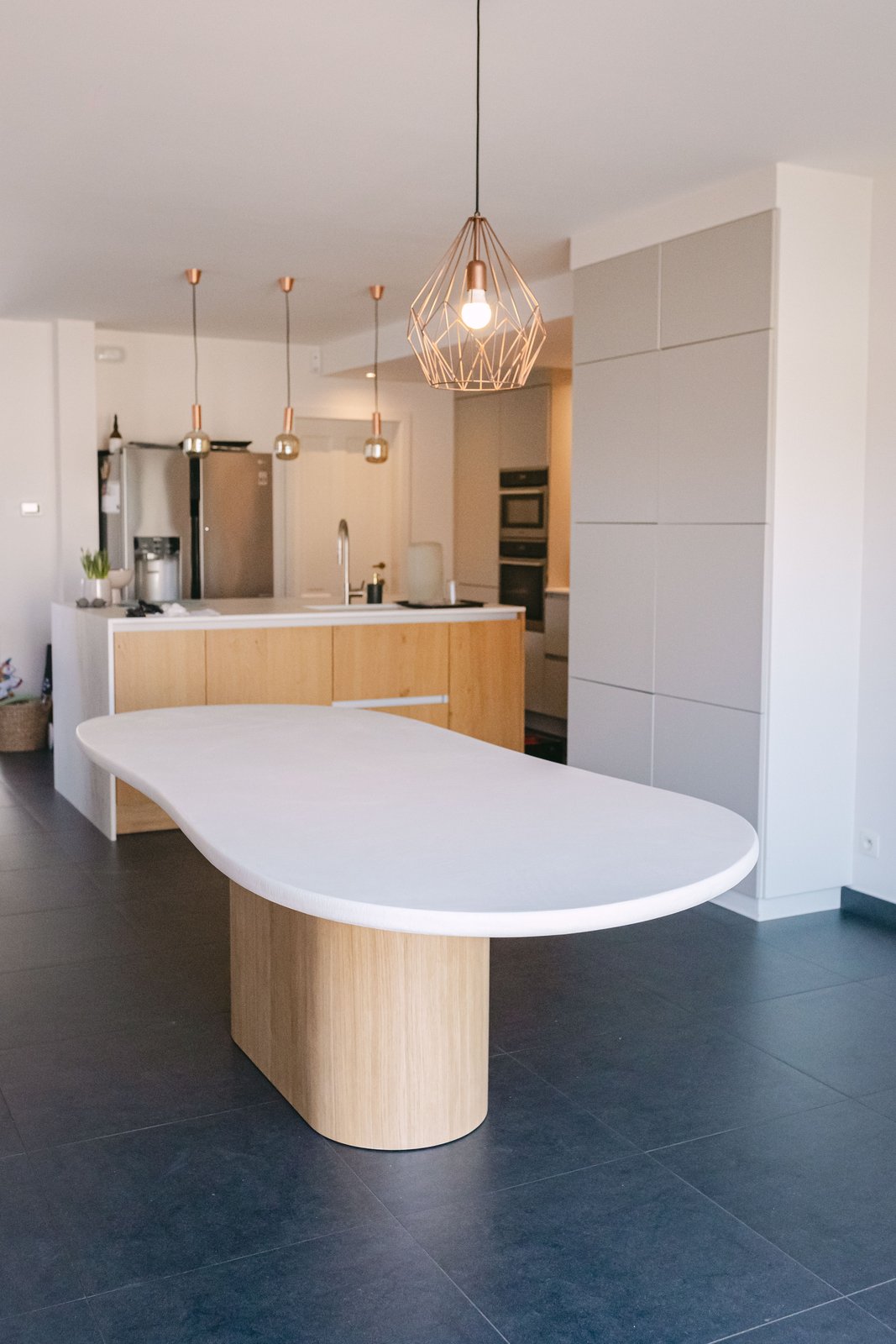 Table ovale en Mortex® teinte Lin ouverte sur une cuisine contemporaine